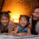 Asian woman playing and staying in tent with her daughter and having fun with camping tent in their bedroom 