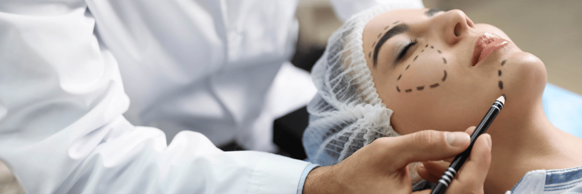 Doctor preparing female patient for cosmetic surgery in clinic