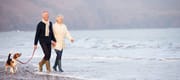 Retired couple walking on the beach.
