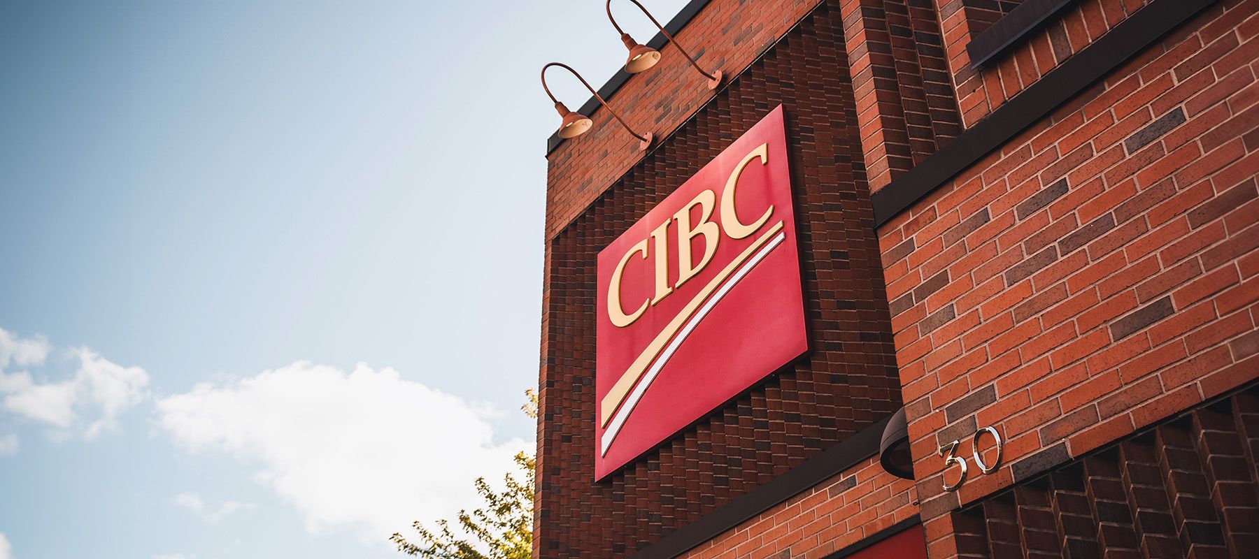 low shot of CIBC bank and its signage with a blue sky in the background