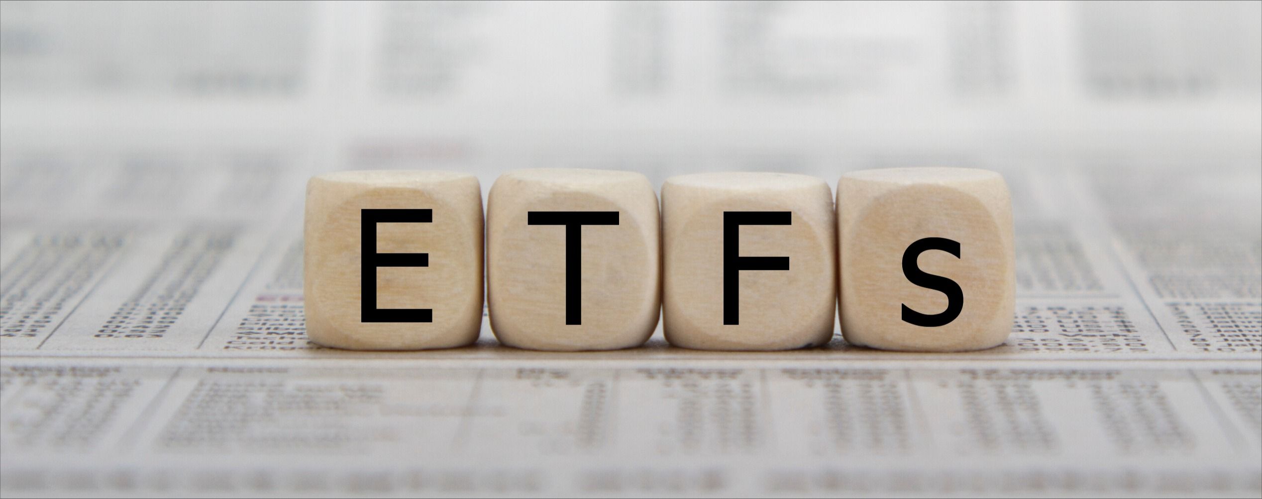 ETF exchange trades funds word on a blurred business newspaper