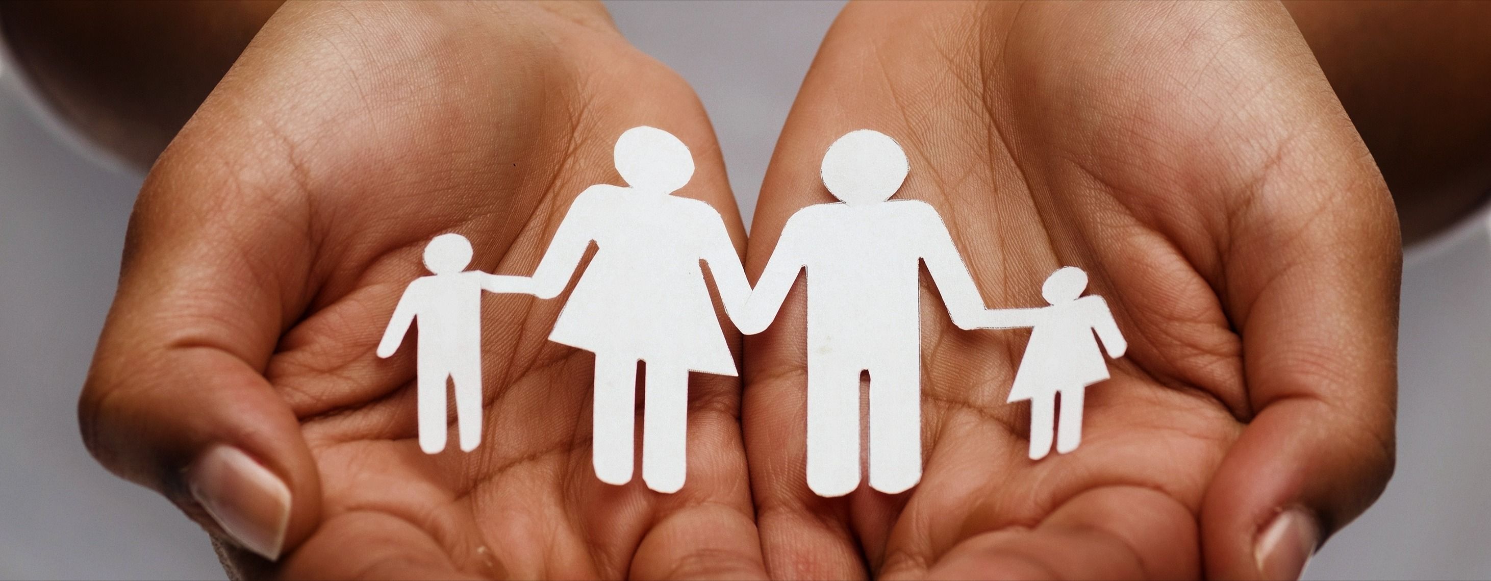 closeup of woman's cupped hands showing paper man family