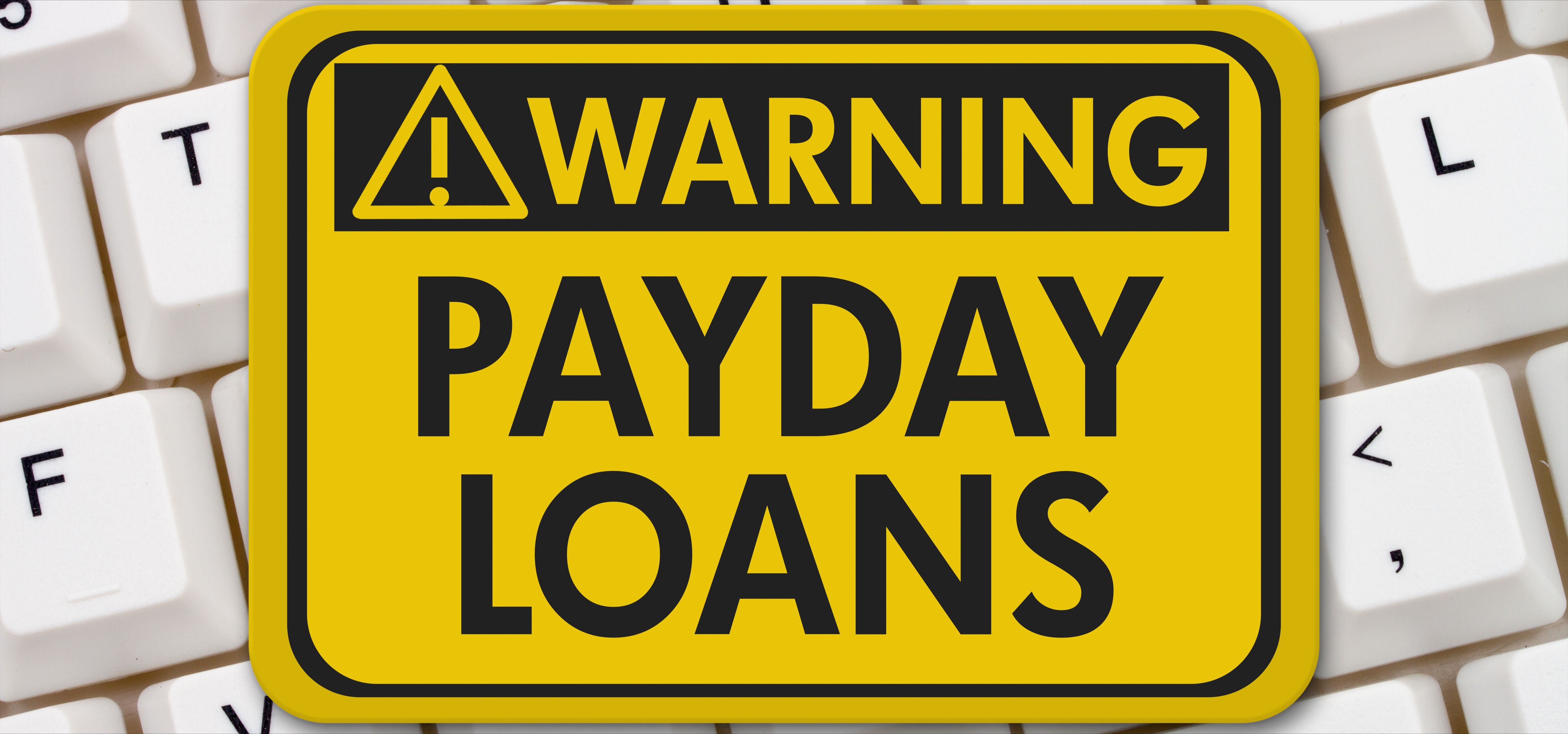 A yellow warning sign with text Payday Loans