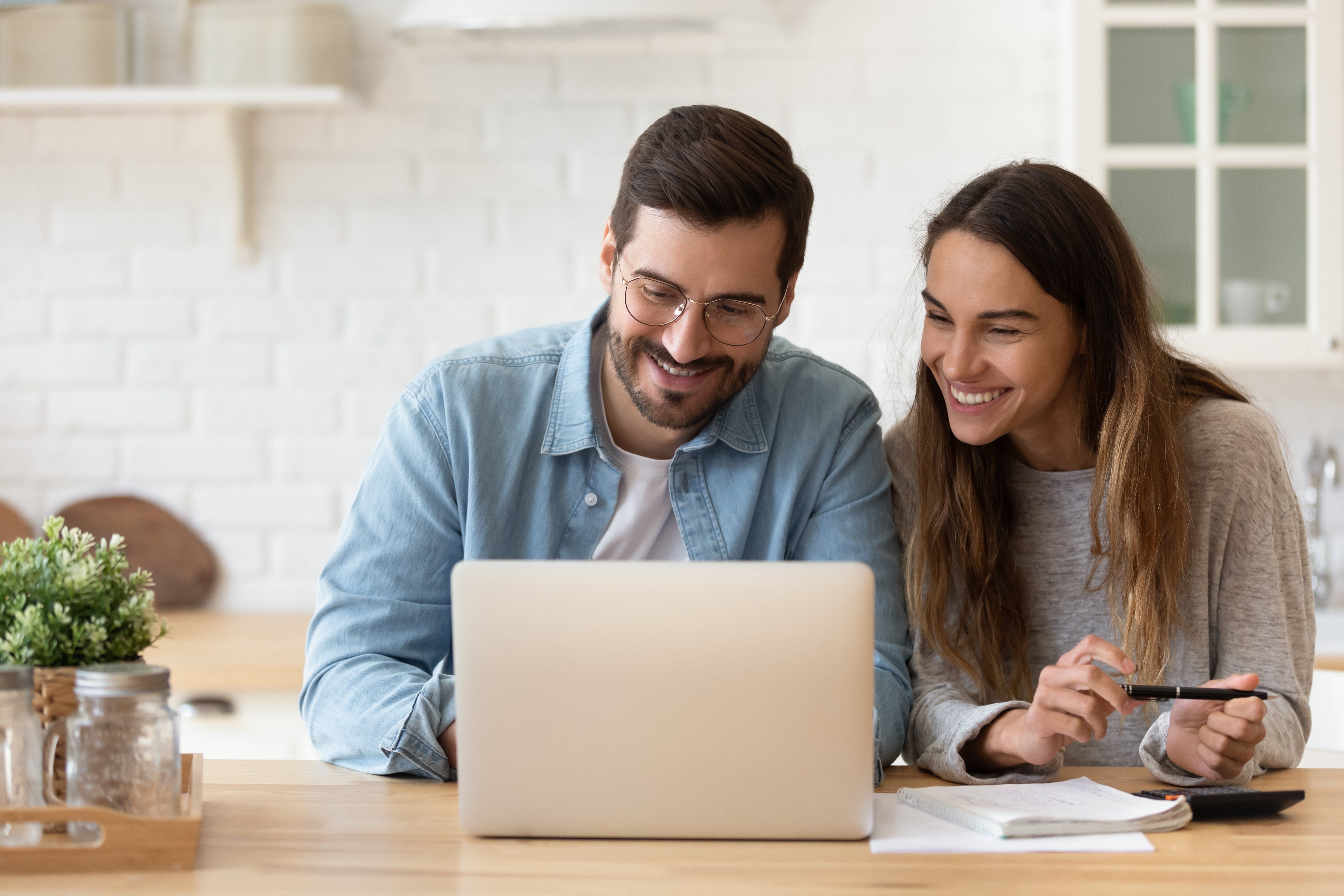Happy young couple planning budget, reading good news in email, refund or mortgage approval