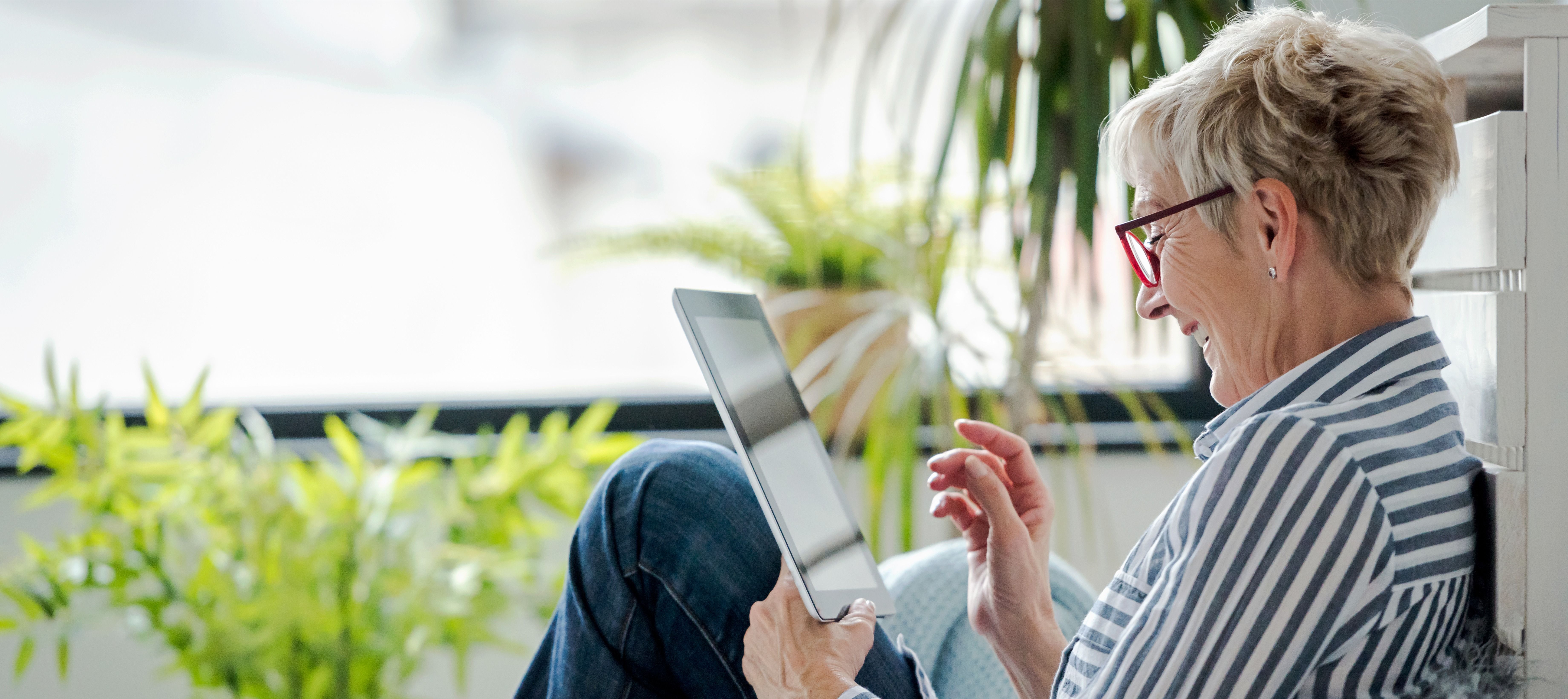 Senior woman using digital tablet at home