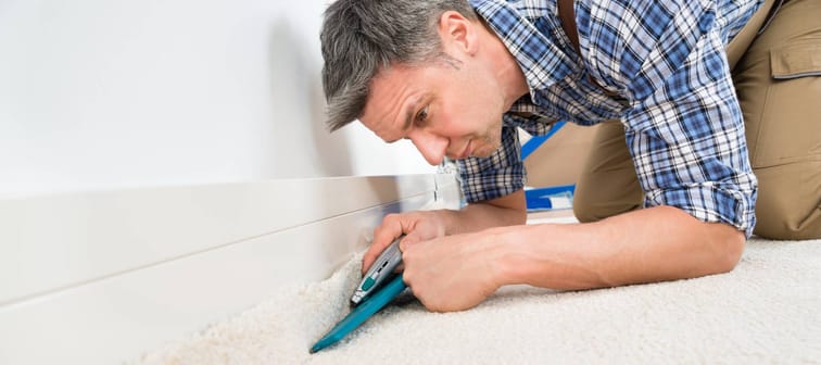 Tradesman installing carpet