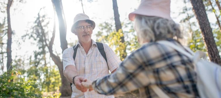 Husband holding hands of wife while walking in park
