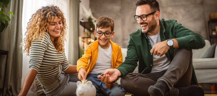 Happy family teaches child how to save