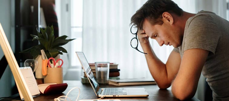 Man stressed while working on laptop