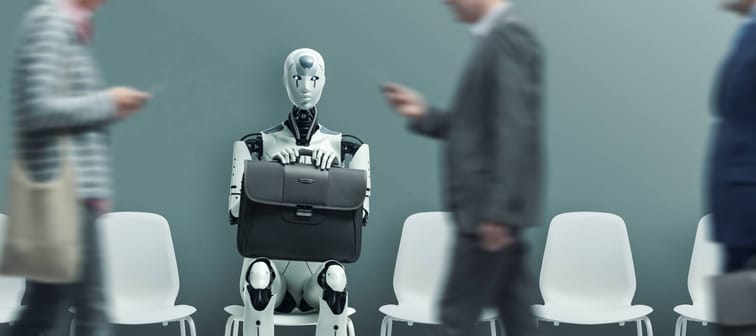 AI robot sitting waiting in a room as humans walk past