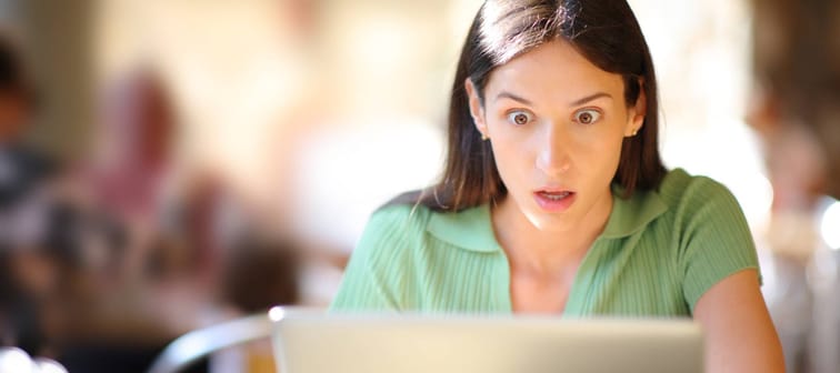 Shocked woman sits in front of her laptop