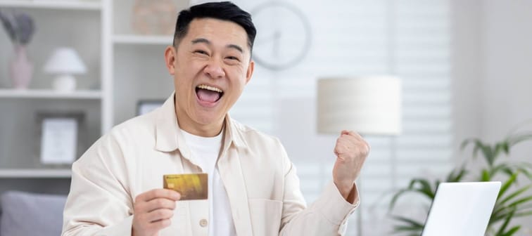 Man holding credit card looking excited