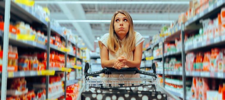 Woman looking overwhelmed while shopping in a grocery store