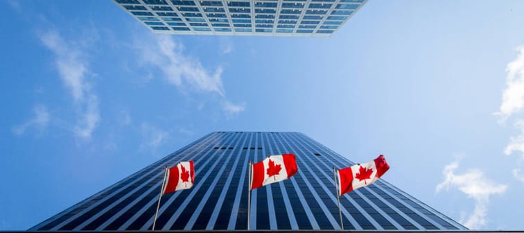 Three Canadian flags in front of a business building in Ottawa