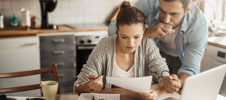 Young couple going over their bills at home in the kitchen