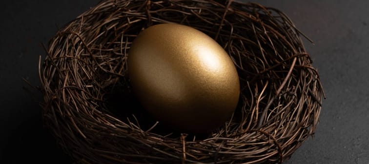 Easter Gold egg in nest on black background.