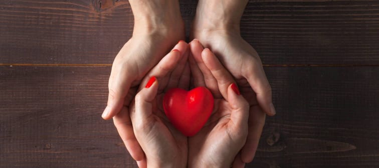 Two hands holding red heart