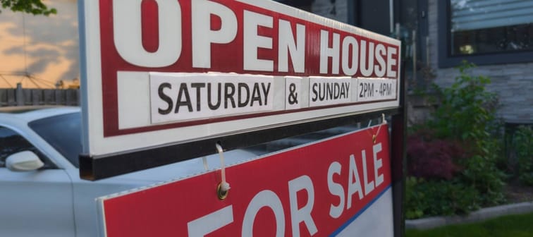 Sign for sale open house in front of detached house in residential area.