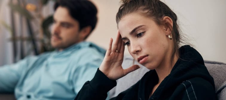 Young woman and man looking stressed on the couch