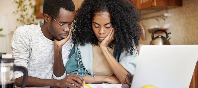 Young stressed couple looking at paperwork