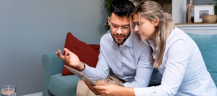 Young couple on sofa discussing finances