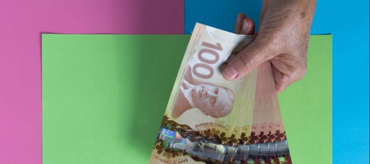 Overhead of senior person holding bills.