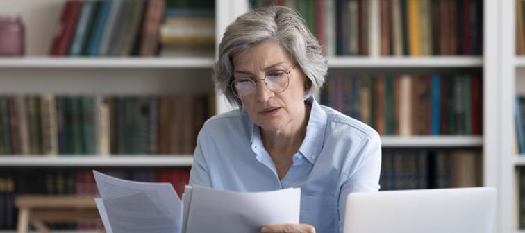 Serious thoughtful middle-aged woman in glasses looks worried