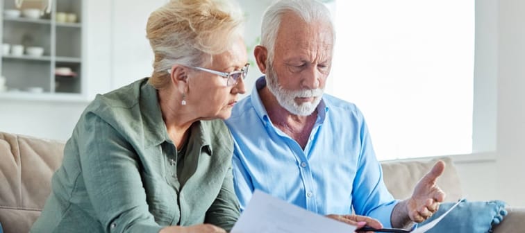 Senior couple checking bills and calculating expenses