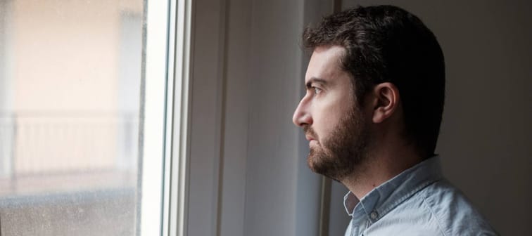 Portrait of sad man looking out of the window