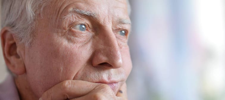 Retired senior looking into the distance, worried.