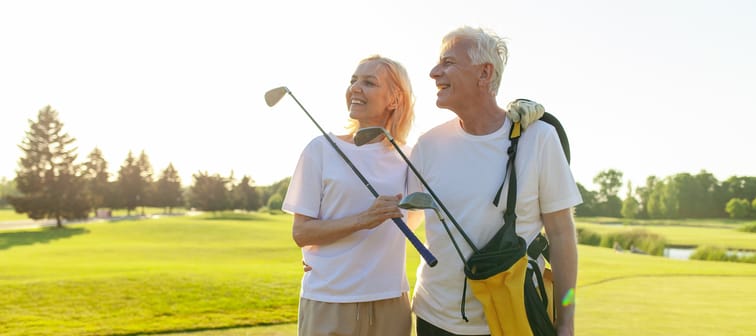 Older wealthy couple standing together on the golf course