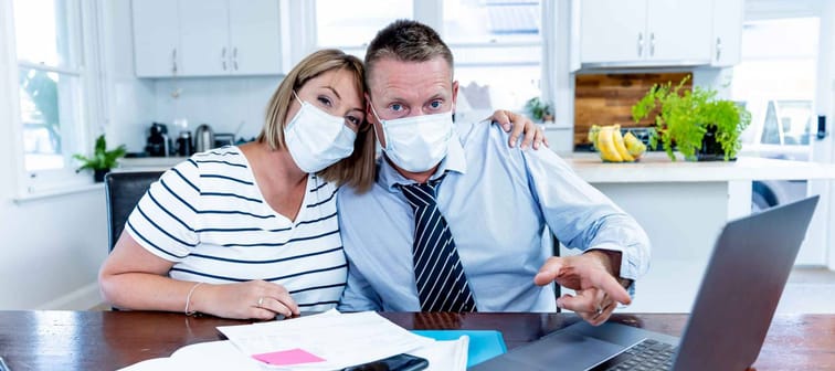 Stressed couple with masks in self-isolation over home finances