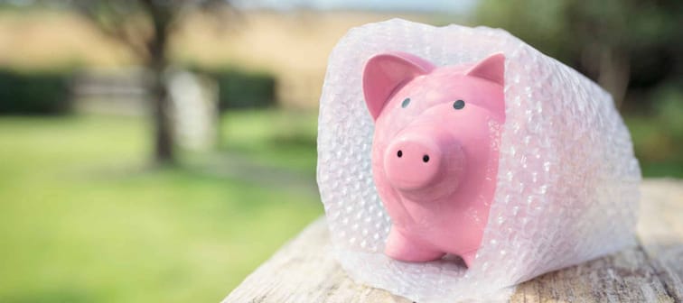 Piggy bank wrapped in bubble wrap, protecting your savings and money
