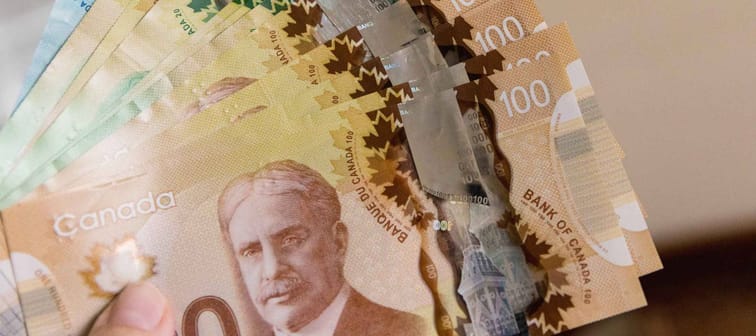 Canadian Dollars, concept of business and finance. Canadian banknotes of different values in hand.