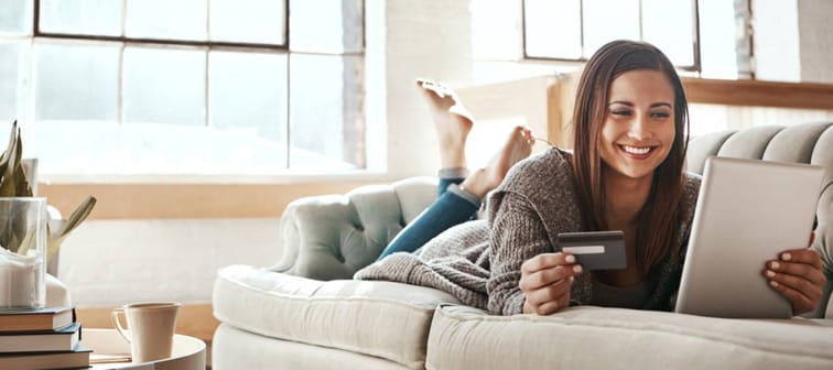 Woman lying on couch reviewing her credit score