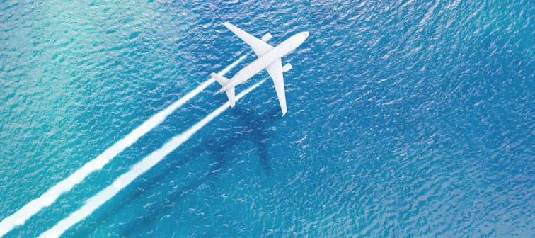 an airplane flying over a beach