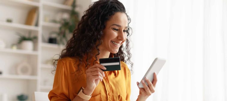 Mobile Shopping. Cheerful Arabic Woman Using Smartphone Shopping Online Holding Credit Card