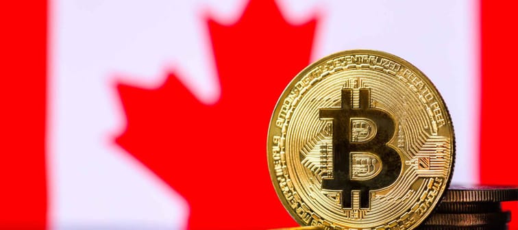 Gold metal coin Bitcoin on the background of the flag of   Canada . Concept for investors in cryptocurrency and Blockchain technology .Legalization of Bitcoin