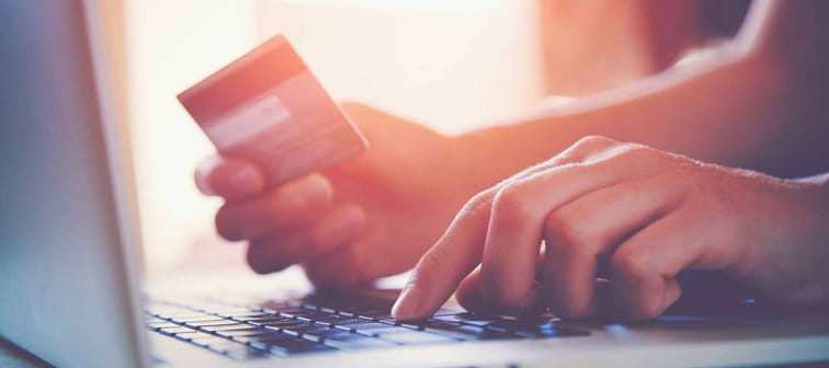 Hands holding credit card and using laptop. Online shopping