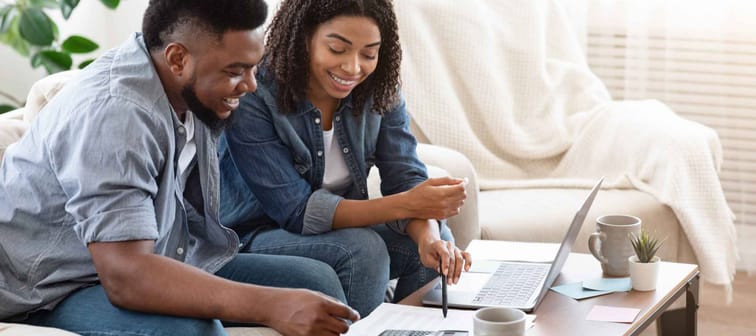 Household Budget. Smiling Black Couple Discussing Total Amount Of Their Spends At Home, Happy About Wise Planning