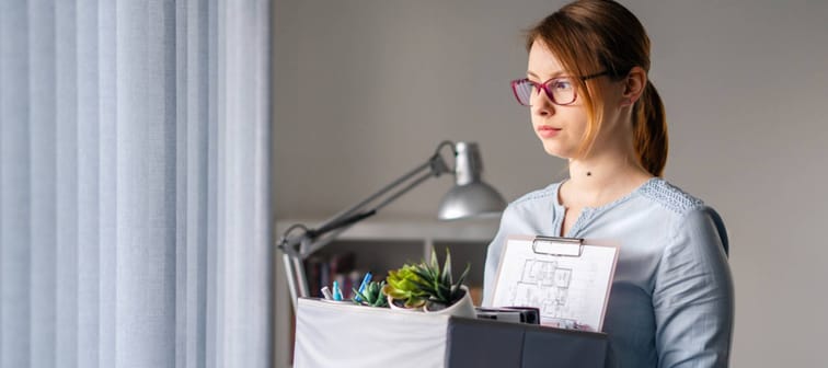 Woman with banker's box full of office supplies