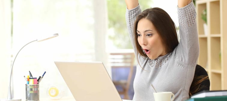 Euphoric and surprised winner winning online watching a laptop at home