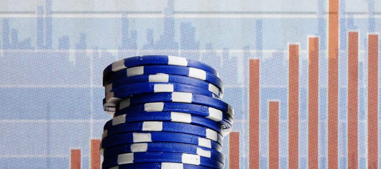 Blue poker chips on stock market chart background