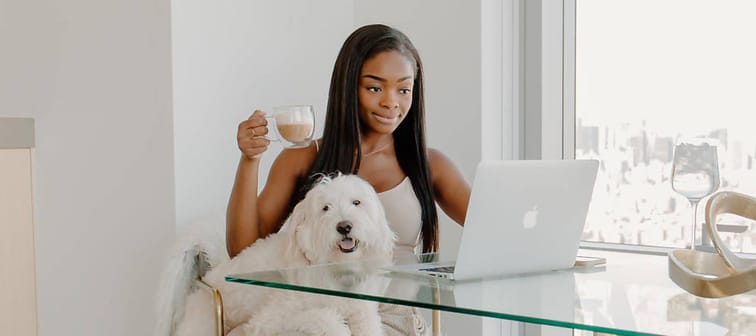 Tay Ladd sits in her Manhattan apartment with her dog on her lap.