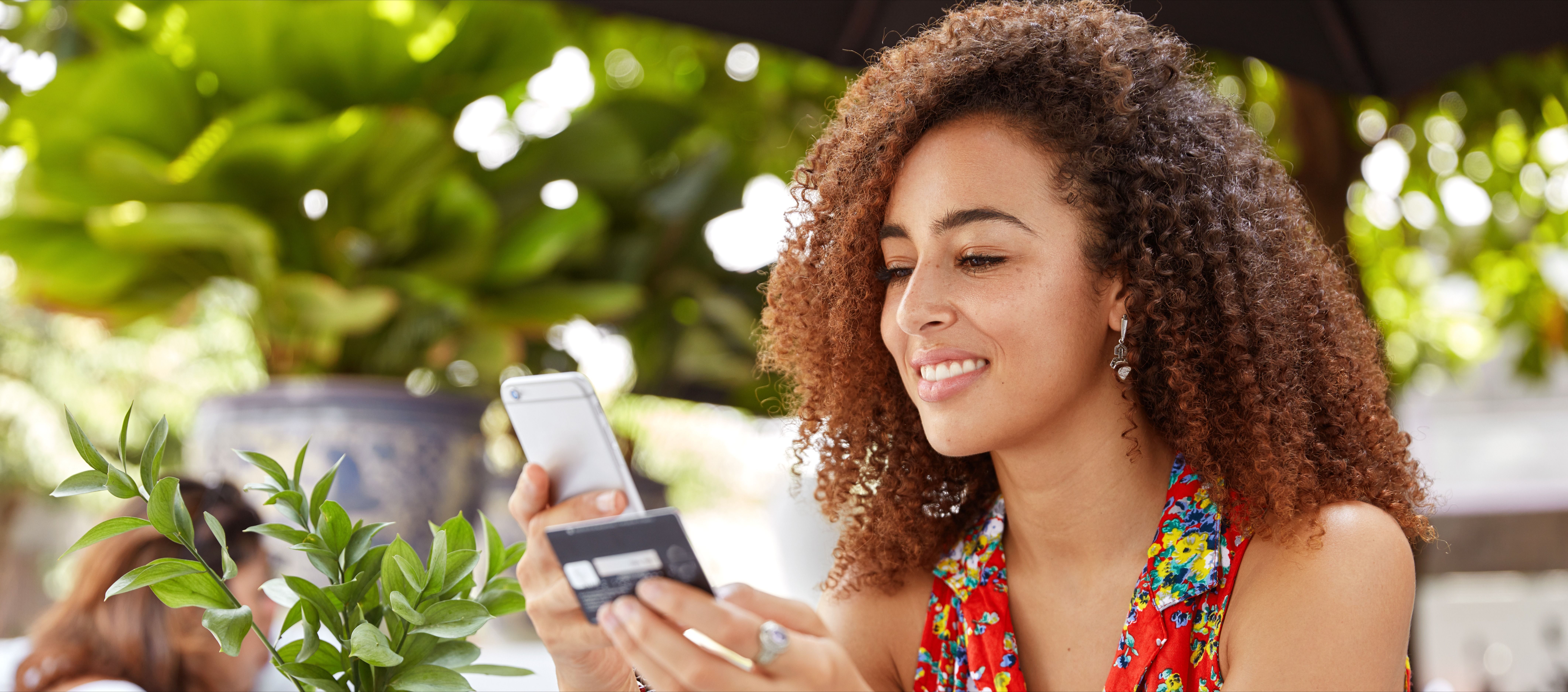 Young woman holding credit card and smart phone