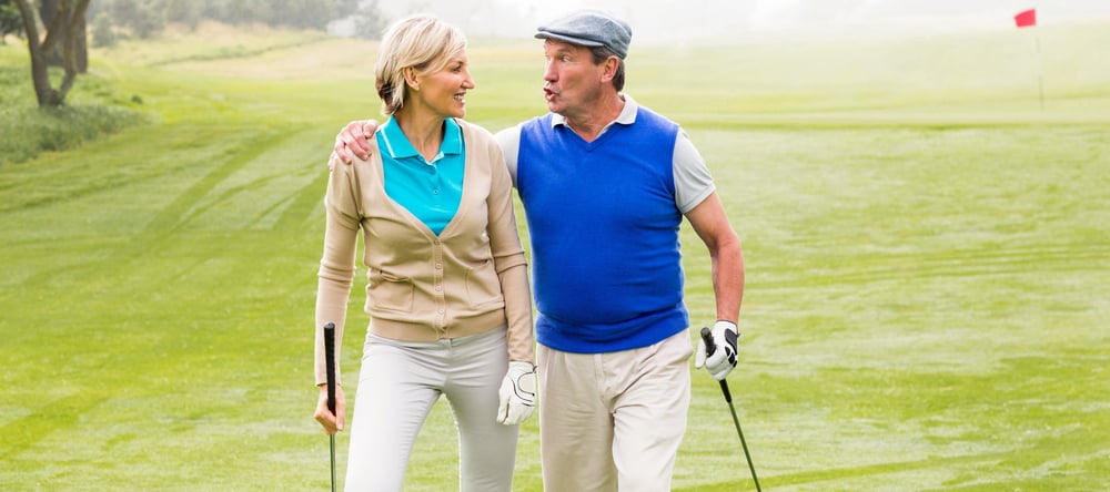 Retired couple chatting while on the golf course