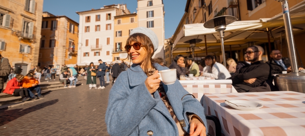 Woman enjoying a coffee at an outdoor Italian cafe