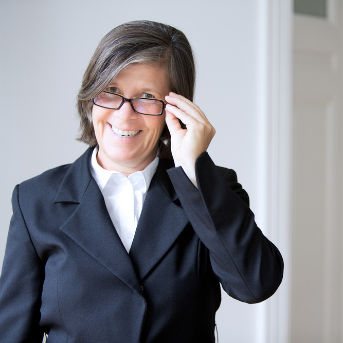 Older woman smiling and taking off her glasses