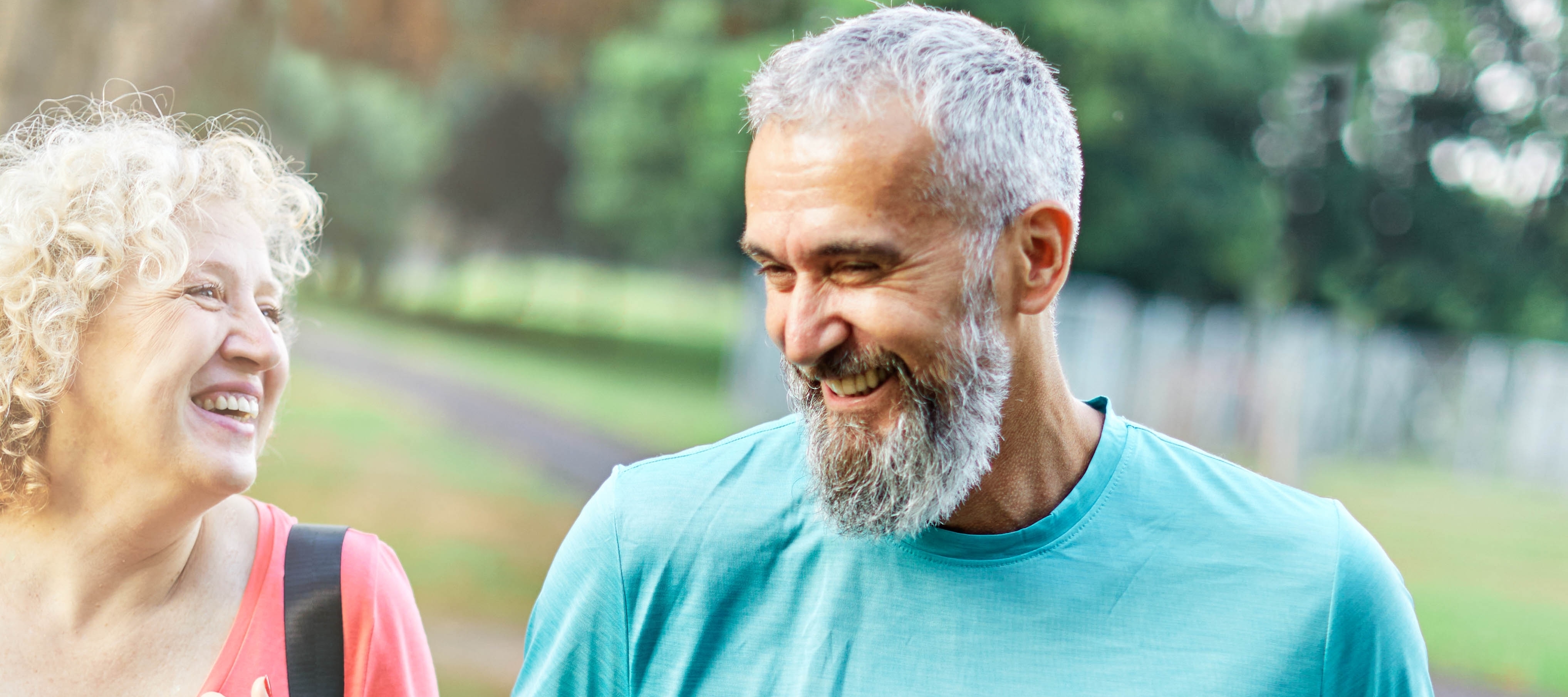 Happy active middle aged couple having fun talking and bonding after having a yoga pilates exercise in park outdoors