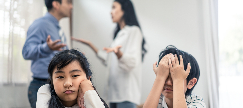 Two young children upset as parents fight at home.